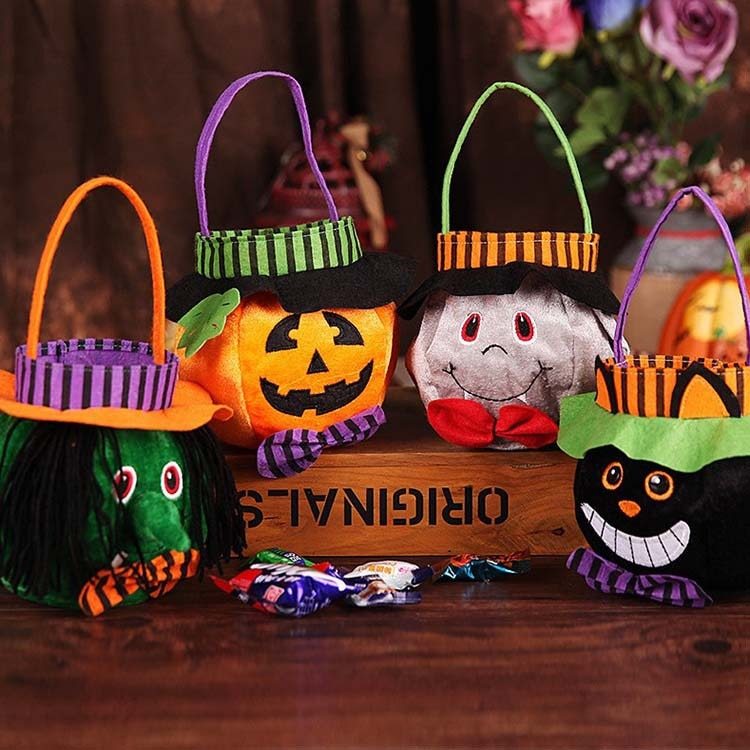Set of Halloween-themed candy baskets on a wooden surface with a decorative background.