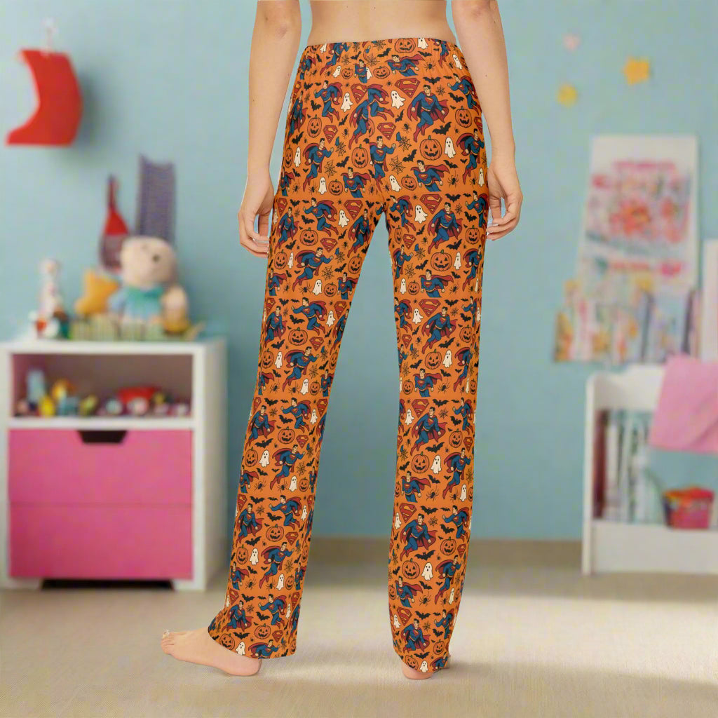 Halloween-themed pajama pants with pumpkins and ghosts on an orange background.